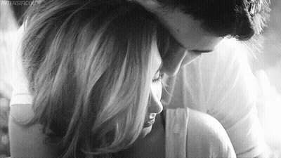 A Man Is Hugging A Woman In A Black And White Photo . GIF