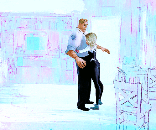 A Man Is Hugging A Woman In A Room With Chairs GIF