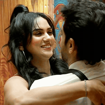A Man Is Hugging A Woman Who Is Smiling GIF