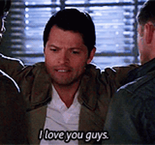 A Man Is Hugging Another Man And Saying `` I Love You Guys '' While Standing In Front Of A Window . GIF