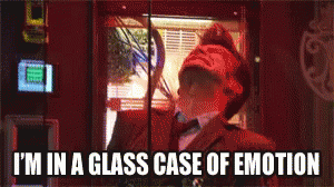 A Man Is In A Glass Case Of Emotion While Looking Out A Window GIF