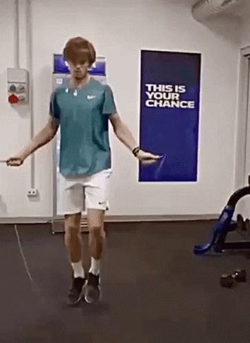 A Man Is Jumping A Jump Rope In Front Of A Sign That Says " This Is Your Chance " GIF