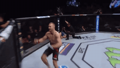 A Man Is Jumping In The Air In A Boxing Ring GIF
