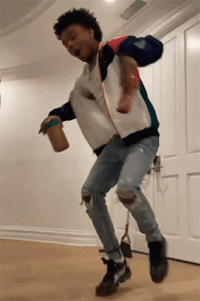 A Man Is Jumping In The Air While Holding A Can Of Peanut Butter . GIF