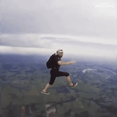 A Man Is Jumping In The Air With A Backpack On His Back GIF
