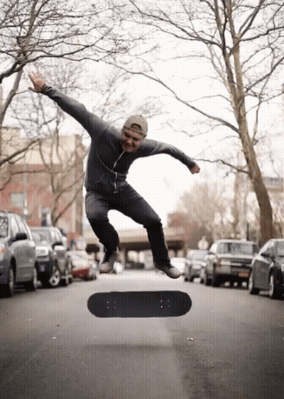 A Man Is Jumping In The Air With A Skateboard In The Foreground GIF