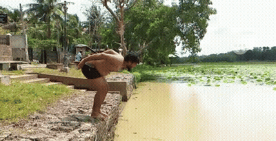 A Man Is Jumping Into A Body Of Water GIF