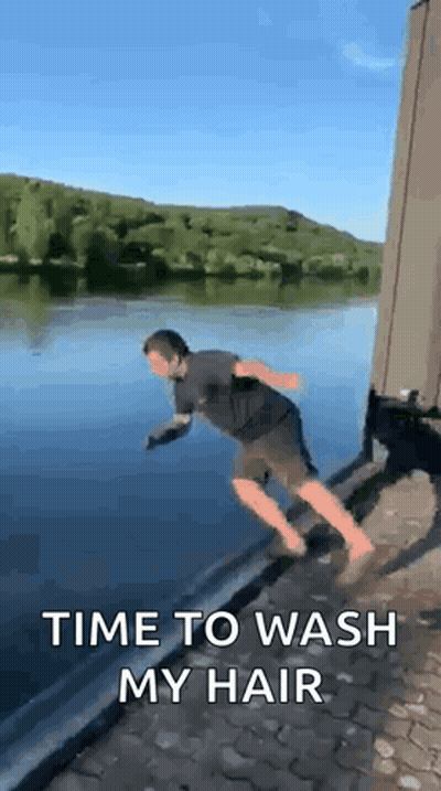 A Man Is Jumping Into A Body Of Water With The Words `` Time To Wash My Hair '' . GIF