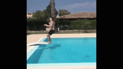 A Man Is Jumping Into A Swimming Pool . GIF