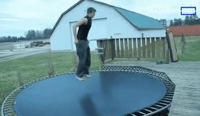 A Man Is Jumping On A Trampoline In Front Of A Barn And A Sign That Says Globe News GIF
