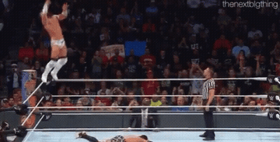 A Man Is Jumping Over Another Man In A Wrestling Ring . GIF