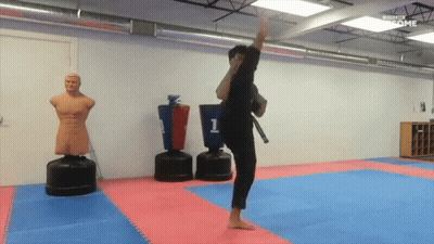A Man Is Kicking A Punching Bag That Says 1 On It GIF