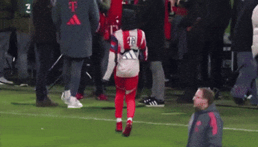 A Man Is Kicking A Soccer Ball On A Soccer Field With A Crowd Watching . GIF