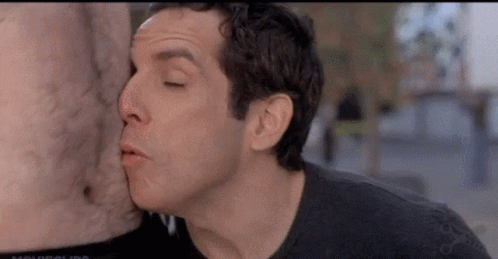 A Man Is Kissing A Statue Of A Man 'S Chest . GIF