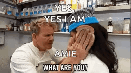 A Man Is Kissing A Woman On The Cheek In A Kitchen While Holding A Piece Of Bread . GIF