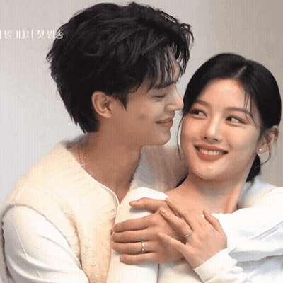 A Man Is Kissing A Woman On The Cheek With A Ring On His Finger GIF