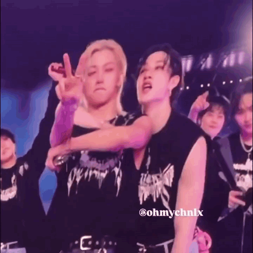 A Man Is Kissing Another Man On The Cheek On Stage . GIF