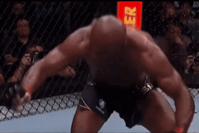 A Man Is Kneeling Down In A Boxing Ring With A Red Sign In The Background That Says Gr GIF
