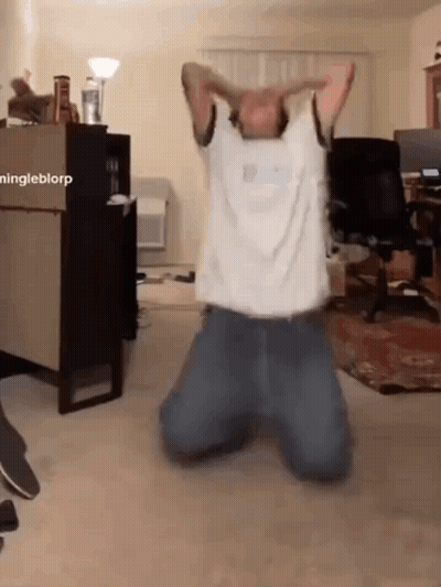 A Man Is Kneeling Down In A Living Room With His Arms Outstretched GIF