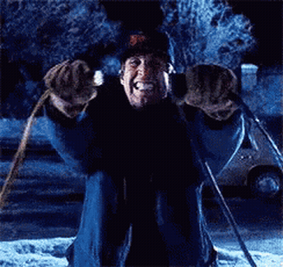 A Man Is Kneeling Down In The Snow Holding A Pair Of Skis GIF