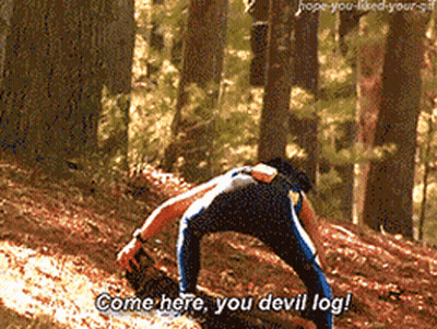 A Man Is Kneeling Down In The Woods And Saying " Come Here You Devil Log " GIF