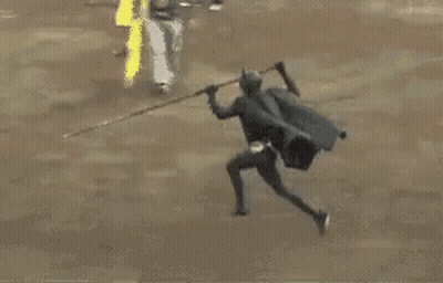 A Man Is Kneeling Down Next To A Bull In A Ring . GIF