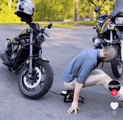 A Man Is Kneeling Down Next To A Motorcycle With A Pumpify Logo In The Corner GIF
