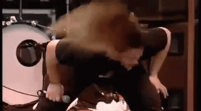 A Man Is Kneeling Down On A Stage With A Microphone In Front Of Him . GIF