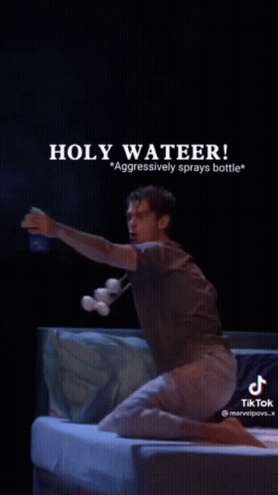 A Man Is Kneeling On A Bed Holding A Bottle Of Water And A Bottle Of Marshmallows . GIF