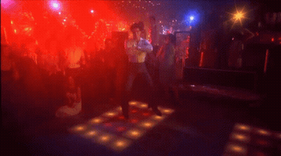 A Man Is Kneeling On A Dance Floor In A Club . GIF