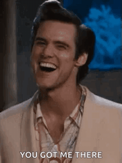 A Man Is Laughing And Saying `` You Got Me There '' While Wearing A Suit . GIF