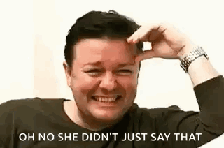 A Man Is Laughing And Touching His Forehead With His Hand . GIF