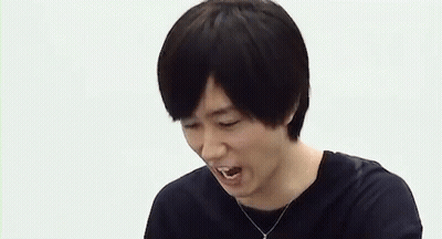 A Man Is Laughing While A Person Points At Him . GIF