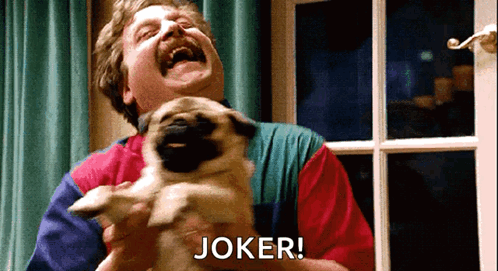 A Man Is Laughing While Holding A Pug Dog And The Word Joker Is Above Him GIF