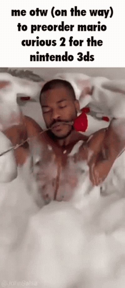 A Man Is Laying In A Bathtub Holding A Rose In His Mouth . GIF