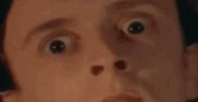 A Man Is Laying In A Bed With His Eyes Closed And A Polka Dot Blanket . GIF