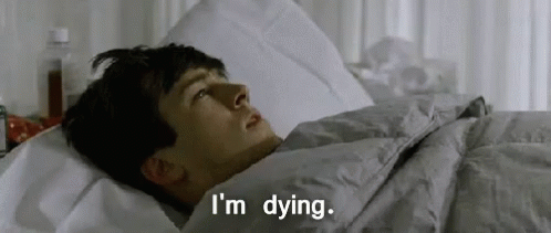 A Man Is Laying In A Bed With The Words `` I 'M Dying '' Written On The Bottom . GIF