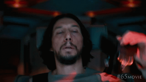 A Man Is Laying In A Dark Room With # 65 Movie Written On The Bottom Right GIF