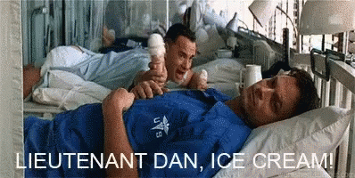 A Man Is Laying In A Hospital Bed Eating Ice Cream GIF