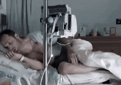a man is laying in a hospital bed with an iv in his arm