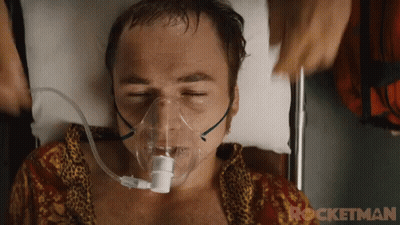 a man is laying in a hospital bed with an oxygen mask on his face ..