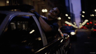 A Man Is Laying In A Police Car With The Words Tech Noir On The Bottom GIF