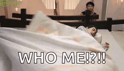 A Man Is Laying In Bed With A White Blanket And The Words `` Who Me ? '' Written On It . GIF