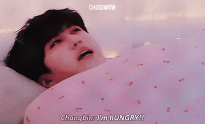 A Man Is Laying In Bed With His Mouth Open And Says Changbin I 'M Hungry ! GIF