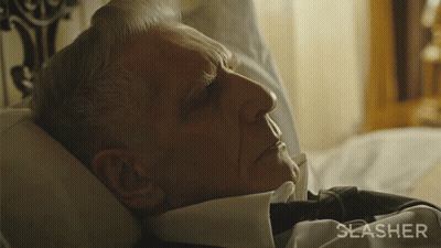 A Man Is Laying In Bed With The Word Slasher On The Bottom Right GIF