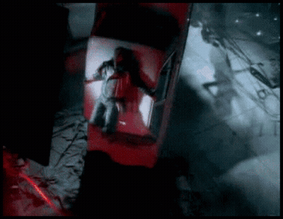 A Man Is Laying In The Back Of A Red Car In A Dark Room GIF