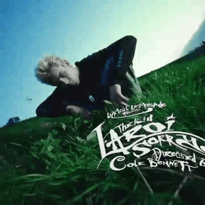 A Man Is Laying In The Grass With The Words " The Kid " On It GIF