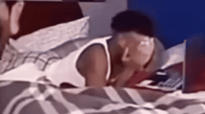 A Man Is Laying On A Bed With A Laptop GIF