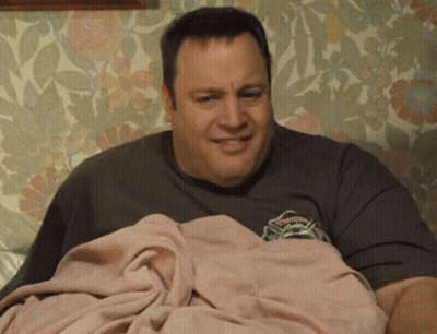 A Man Is Laying On A Bed With A Pink Blanket On Top Of Him . GIF