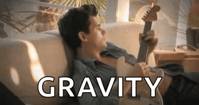 A Man Is Laying On A Couch Playing A Guitar And The Word Gravity Is Above Him . GIF